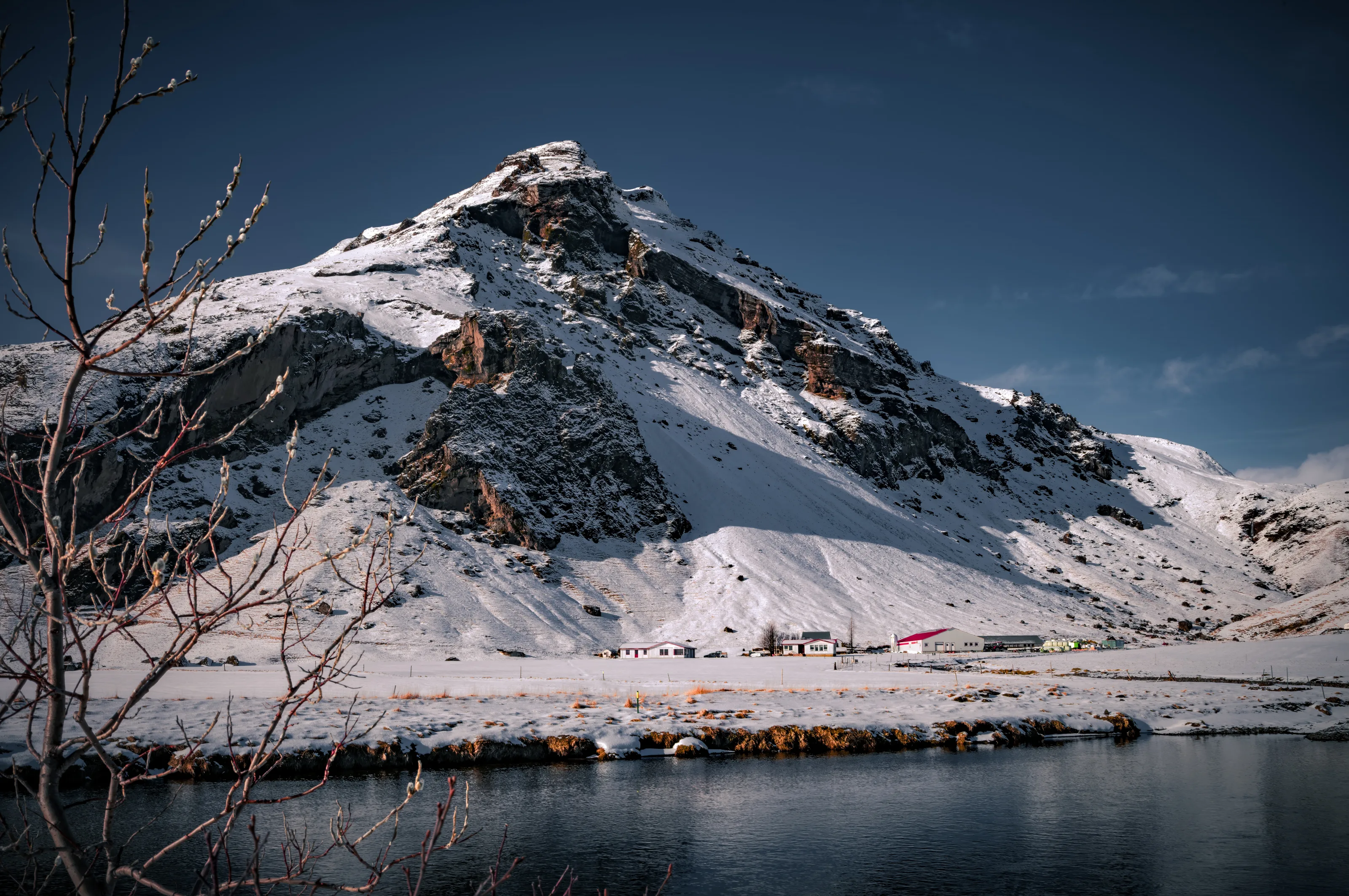 Snow-covered mountain cottages reflected in the still waters of Skógar — Iceland's interior at its quietest and most beautiful.